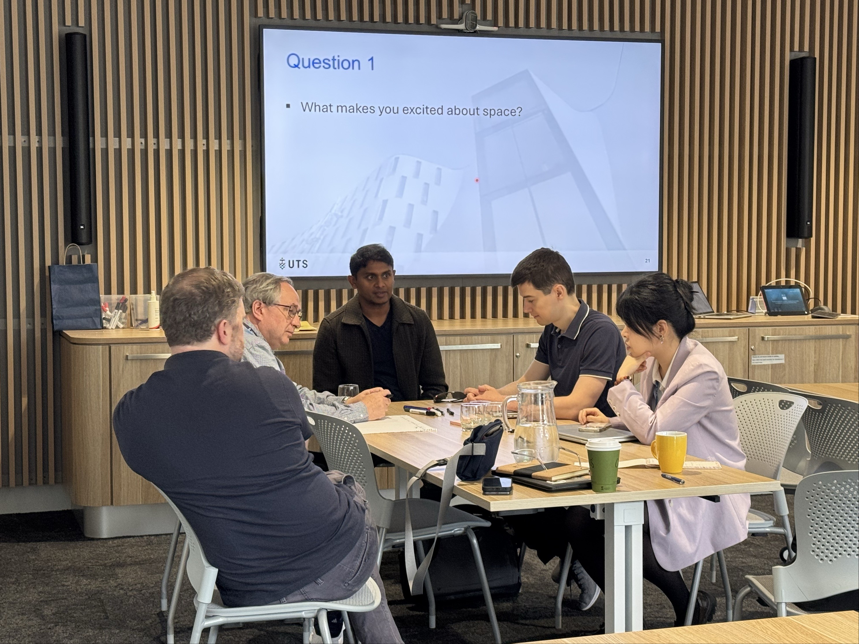 a group of people talking at a table 