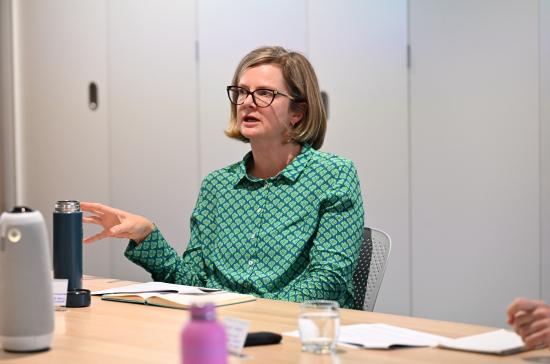 Dr Heather Ford seated at a table talking to someone out of picture