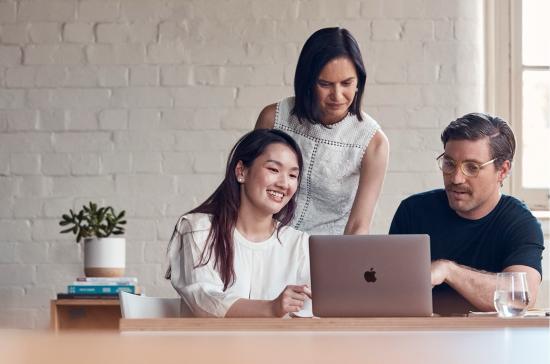 Group of people sitting around laptop