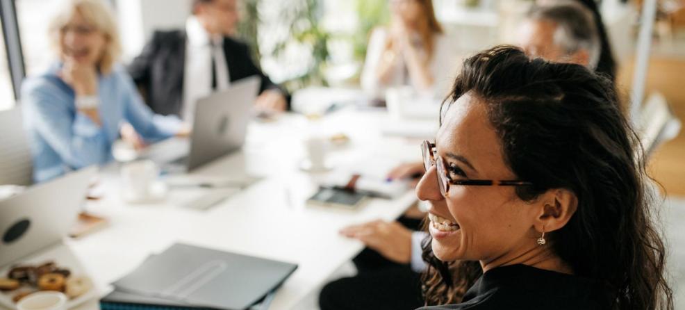 Woman smiling at table with colleagues